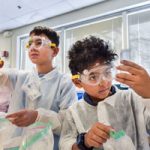 student scientists examine samples in beakers