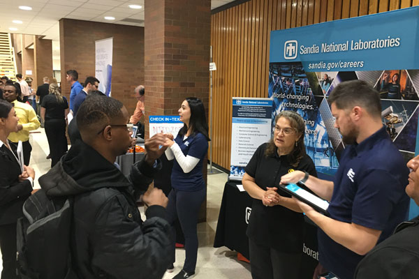 Signers, speakers and interpreters engaged with culturally deaf students at a career fair