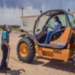 instructor stands by as student operates forklift