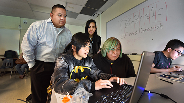 Tony Lona looks on as students apply the new skills they developed that day.