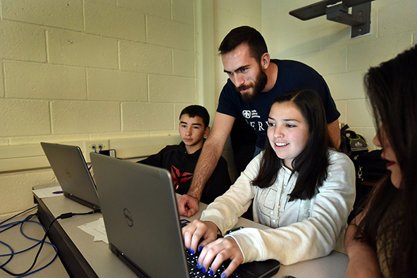 Seanmichael Galvin helps students work through a problem.