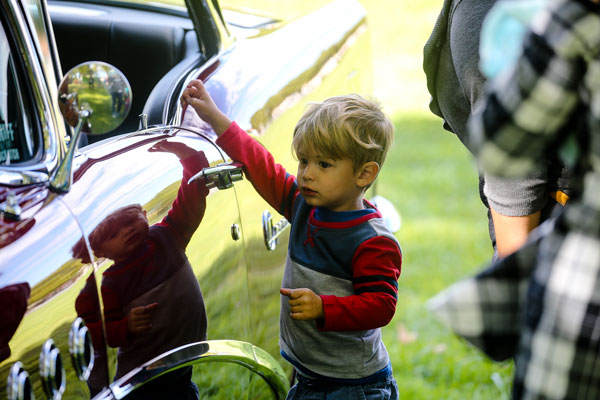 child looks at classic car