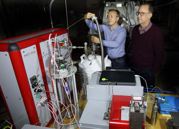 researchers work on lab equipment for hydrogen-powered transportation storage