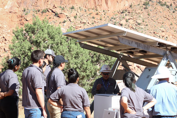 Interns listen to mentor explain solar panel features