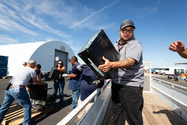 man loads computer onto flatbed trailer