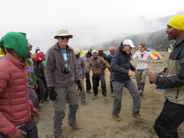 team dances with their guides at base camp