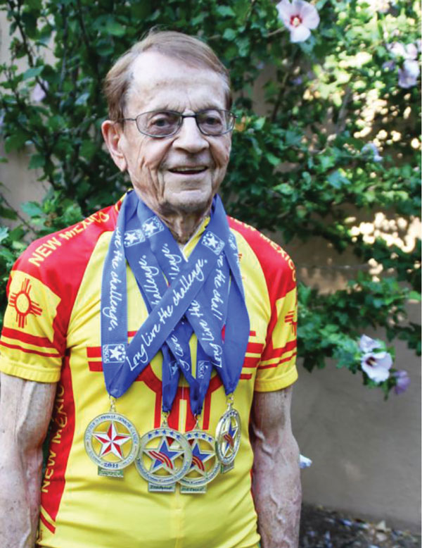 Larry modeling his senior games medals