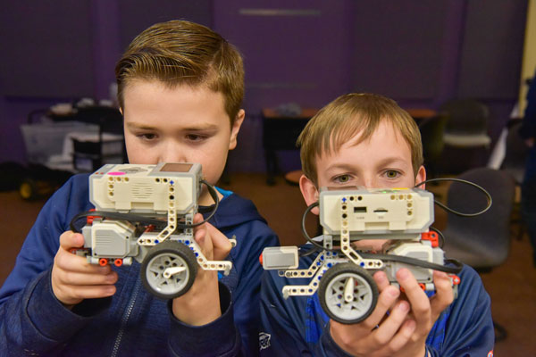 students inspect robot vehicle