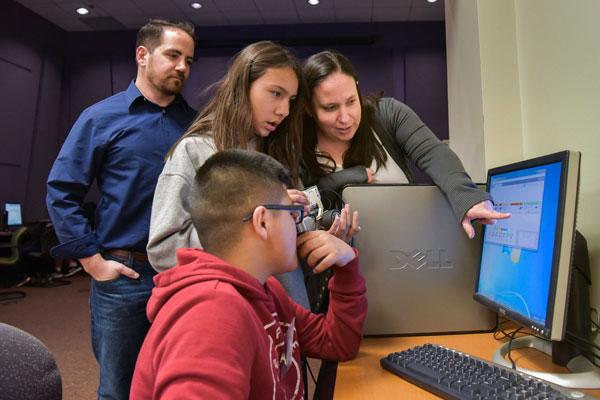 students and volunteers discuss a computer program