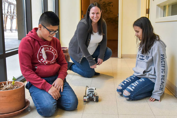 students and volunteer test robot vehicle