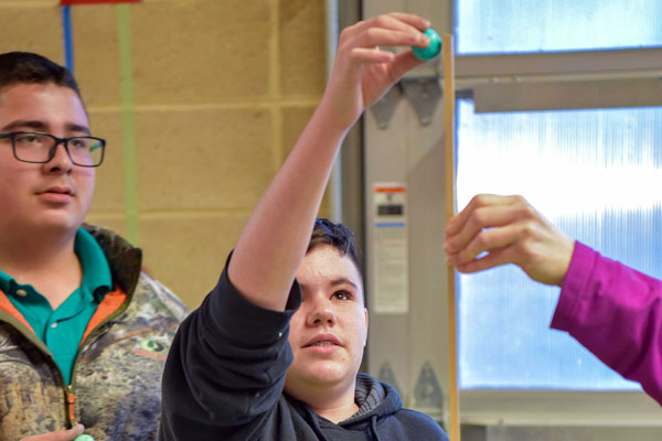 students and volunteer conduct gravity experiment