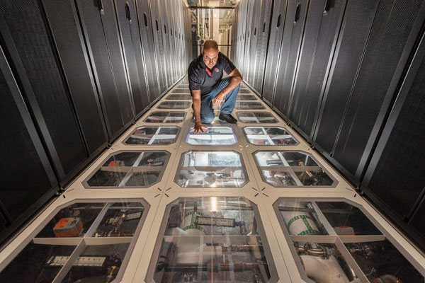 David J. Martinez examines the cooling system at Sandia’s supercomputing center