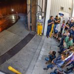 group gathers outside warehouse to view combustion experiment