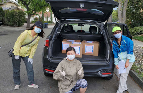 volunteers pack vehicle with PPE donations