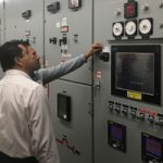 engineers inspect a bank of switchgear