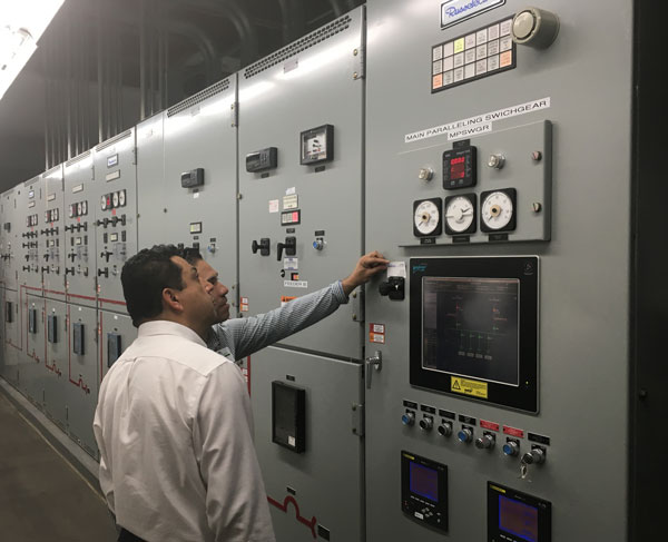 engineers inspect a bank of switchgear