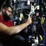 Researcher adjusts engine part in lab