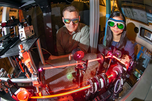 scientists observe laser recording measurements in wind tunnel