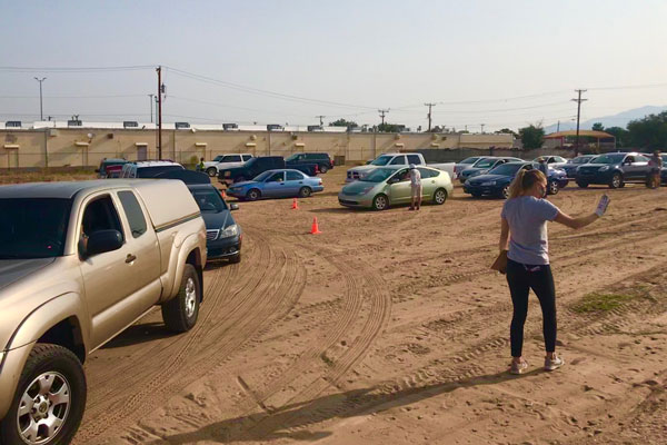 volunteer directs cars at food donation pick-up