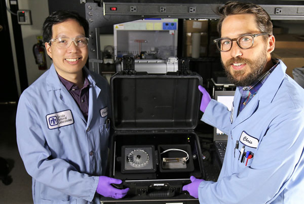 scientists display SpinDx device