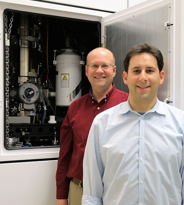 Sandia materials scientists Doug Medlin (left) and Josh Sugar (right) pose in front of Sandia's new transmission electron microscope.