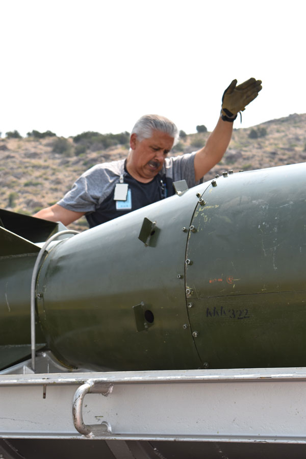 materials handler helps position Fat Man weapon shell on truck