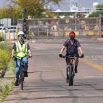 cyclists wearing face masks ride bikes on-site