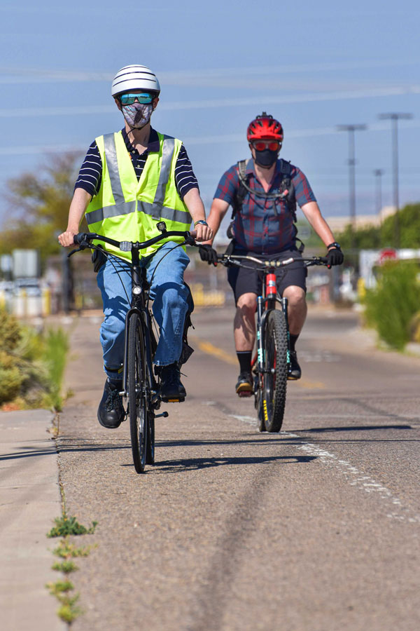 cyclists wearing face masks ride bikes on-site