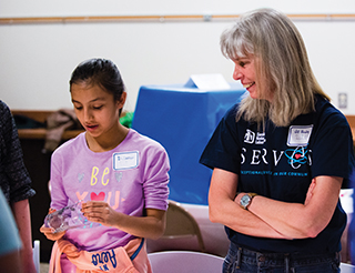 Sandia President and Labs Director Jill Hruby, in photo above, engages with a local student during a “What is Fire?” demonstration at Sandia’s first STEM Mentoring Café, a DOE outreach program to engage middle school girls.