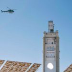 helicopter flies over solar tower