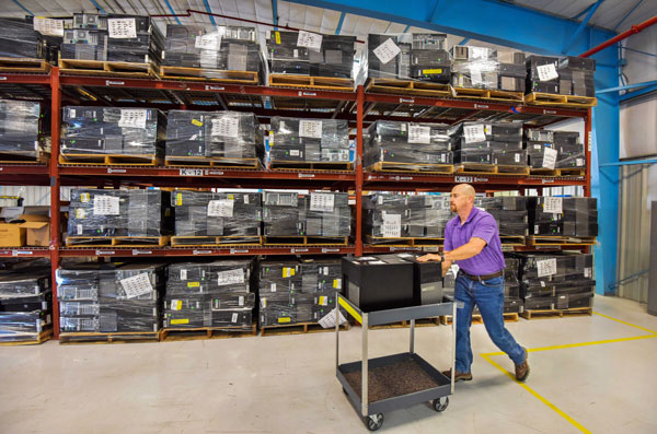 Michael Somuk wheels cart through computer warehouse