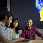 Caption: COOL HEADS — From left, Sandia researchers Giulio Borghesi, Jackie Chen, and Alex Krisman discuss a flame simulation.    (Photo by Dino Vournas)