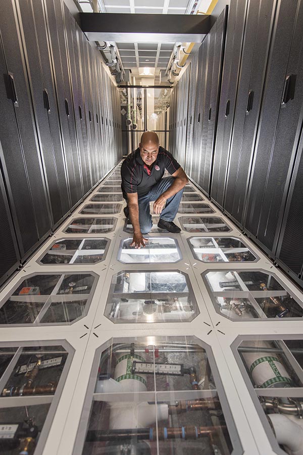 Sandia engineer David J. Martinez examines the cooling system at Sandia’s supercomputing center.  Photo by Randy Montoya