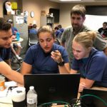 kids work with mentor on cybersecurity challenge
