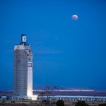 lunar eclipse over solar tower