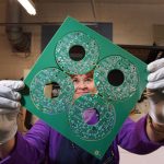 Judy Ortiz Rizek holds a printed circuit board