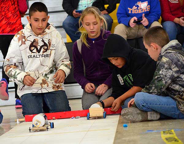 Students watch as their electric cars race down the practice track during the New Mexico Electric Car Challenge.