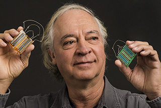 RESEARCHER JUAN ELIZONDO-DECANINI holds two compact, high-voltage nonlinear transmission lines. Juan leads a project on nonlinear behavior in materials — behavior that’s usually shunned because it’s so unpredictable. (Photo by Randy Montoya)