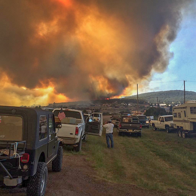Flames approach inhabited areas at the peak of the Dog Head Fire on June 16. Before it was brought under control, the fire claimed more than two dozen homes and other structres. Photo by Michael Tachias.