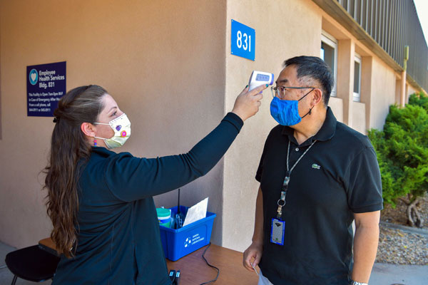 medical worker conducts on-site health check for employee