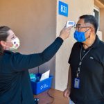 medical worker conducts on-site health check for employee