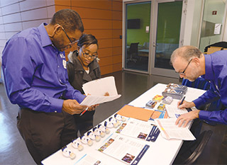 BUILDING RELATIONSHIPS — Sandia recruiters Dennis Owens (423), left, and Tim O’Hern (1512) talk with a Howard University student about career opportunities at Sandia. In addition to serving as a recruiter, Tim works with four to six Howard mechanical engineering students each year to help them complete a capstone design project. “I always tell the student groups that this is what they will be doing after they graduate, whether they go to graduate school or take a job. They need to be able to solve problems that don’t have answers in the back of the book, work as members of an effective team, and communicate their results to a paying customer,” he says. (Photo by Charles Votaw)