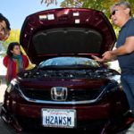 Tadashi Ogitsu shows his hydrogen fuel-cell powered Honda Clarity to celebration attendees