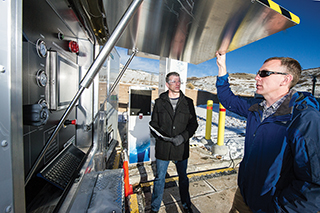 Mechanical engineer Terry Johnson, left, the project leader for the Hydrogen Station Equipment Performance (HyStEP) device, and National Renewable Energy Laboratory researcher Chris Ainscough prepare HyStEP for testing at NREL’s Energy Systems Integration Lab. HyStEP will accelerate hydrogen refueling station commissioning.	(Photo by Dennis Schroeder/NREL)