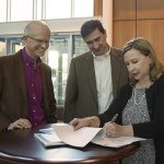 DOING BUSINESS — Industry Partnerships Senior Manager Mary Monson signs a licensing agreement with scientist-turned-entrepreneur Murat Okandan, center, and Research Strategy and Partnerships Director Andy McIlroy. Okandan left Sandia in 2015 through the Entrepreneurial Separation to Transfer Technology program and founded mPower Technology Inc. to commercialize Sandia’s microsystems enabled photovoltaics, also known as solar glitter.            (Photo by Jennifer Knight)