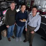    Meta-phorically speaking — Mike Sinclair, left, Sheng Liu, and Igal Brenner stand in the laboratory where work was done to create metamaterials on substrates. One version here is presented by Sheng.  (Photo by Randy Montoya)