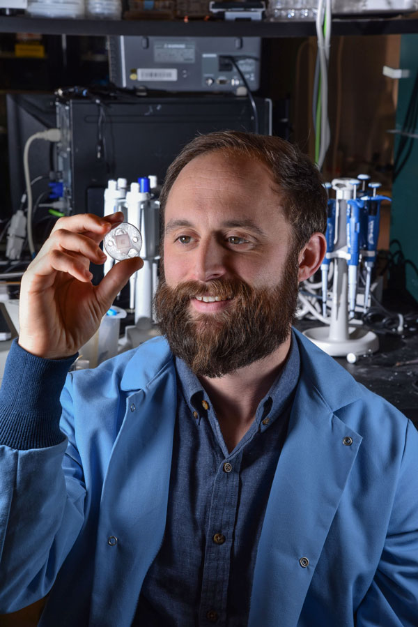 Philip Miller examines a microneedle device