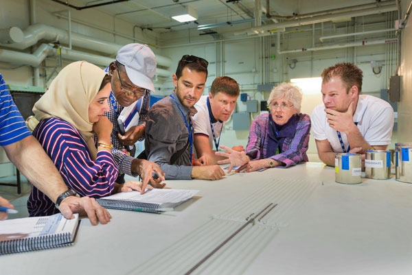 students gather around table to observe nuclear security measures