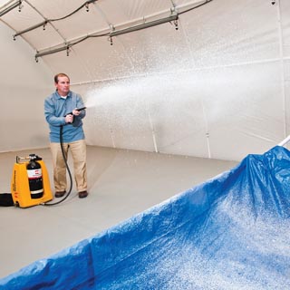 researcher Mark Tucker (6632) demonstrates application of Sandia-developed decontamination foam. The foam, used 10 years ago in the cleanup effort following the deadly 2001 anthrax attacks, is now being used to decontaminate environmentally devastating meth labs.	(Photo by Randy Montoya)