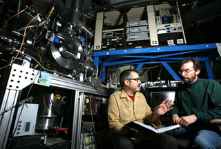 Sandia combustion researchers Craig Taatjes, left, and David Osborn discuss data found from the detection and measurement of Criegee intermediate reactions. The apparatus was used to make the measurements, which researchers believe will substantially impact existing atmospheric chemistry. (Photo by Dino Vournas)